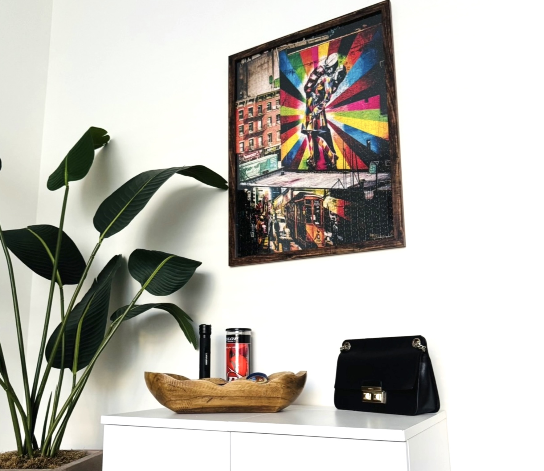 The finished puzzle framed and hung on a living room wall above a console table.