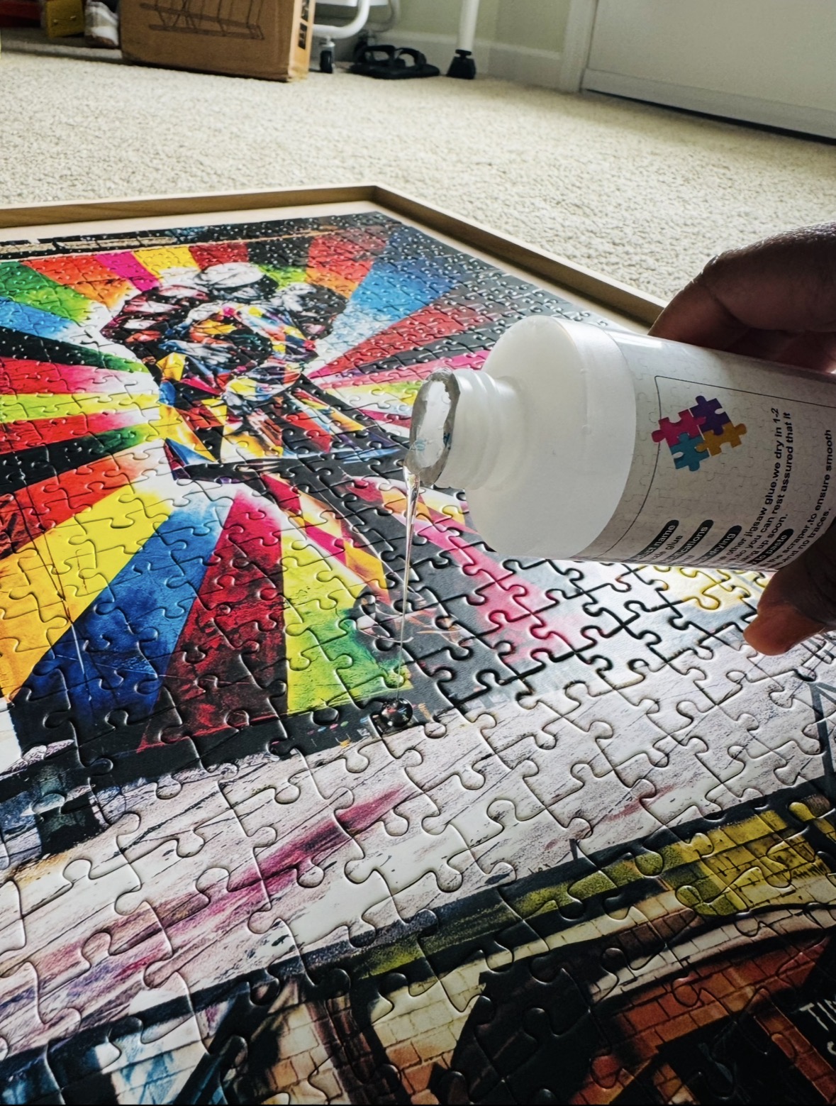 Glue being poured across the surface of the completed puzzle.